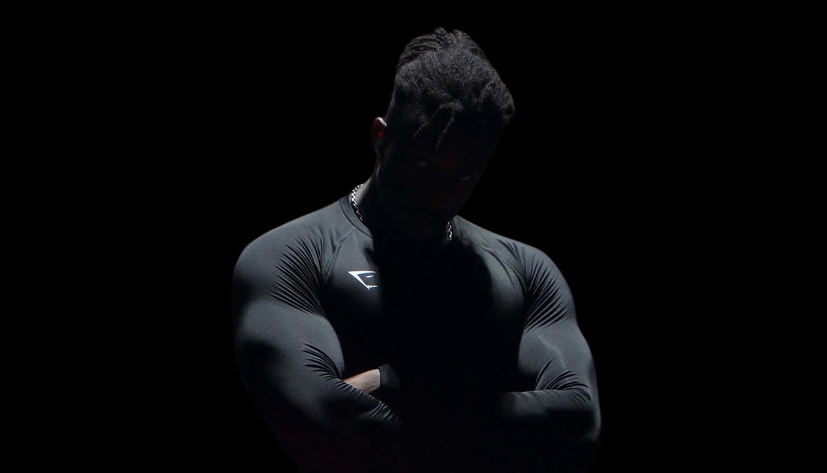 Coach wearing black and looking down.