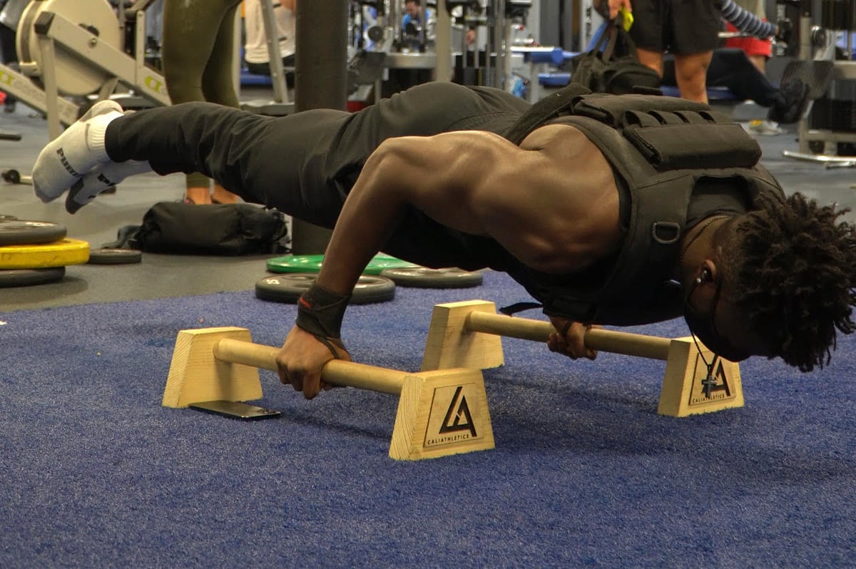 Coach is doing a plank with legs lift.